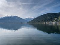 the mountain range is seen across the water, and the lake is calm and quiet