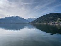 the mountain range is seen across the water, and the lake is calm and quiet