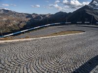 a curved street with mountains behind it in the background to provide a perspective for the curve