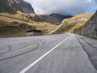 the mountain road has white lines painted on it and is surrounded by mountains and hills