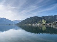 mountains reflected in the still waters of lake luce, switzerland, by an individual on a boat