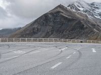 a person riding a motorcycle on the road near mountains and clouds that can be seen