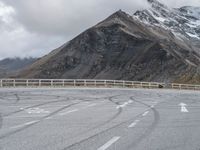 a person riding a motorcycle on the road near mountains and clouds that can be seen