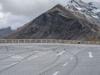 a person riding a motorcycle on the road near mountains and clouds that can be seen