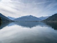 the view of a mountain range and the sky over a large body of water with hills in the background