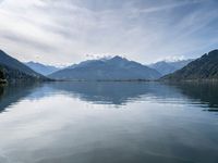 the view of a mountain range and the sky over a large body of water with hills in the background