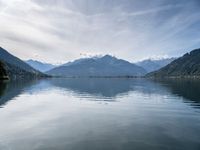 the view of a mountain range and the sky over a large body of water with hills in the background