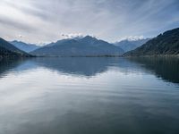 the view of a mountain range and the sky over a large body of water with hills in the background