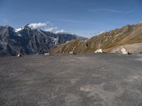 an empty parking lot with mountains in the background and a bird flying high above it