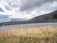 a person riding a motorcycle on a curvy road under stormy skies and clouds