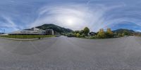 a wide fish eye lens shot of the mountain tops and cars on a road in an upscale area