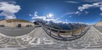 fish eye photo of a mountainous highway with cars driving along it from the top of a high mountain