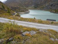 this is an image of a view of the mountains, lake and a roadway in the foreground