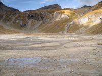 a small area with rocks and snow in the middle of a mountainous area with mountains