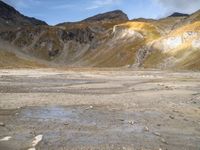 a small area with rocks and snow in the middle of a mountainous area with mountains