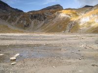 a small area with rocks and snow in the middle of a mountainous area with mountains