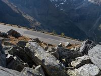 a person is on the road and there are mountains in the background and a road goes by on top