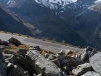 a person is on the road and there are mountains in the background and a road goes by on top