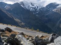 a person is on the road and there are mountains in the background and a road goes by on top