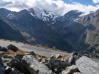 a person is on the road and there are mountains in the background and a road goes by on top