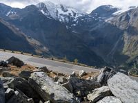 a person is on the road and there are mountains in the background and a road goes by on top