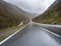 a large open road that goes through the mountains in winter time for walkers and cyclists