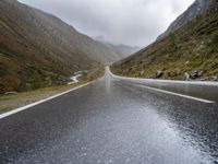 a large open road that goes through the mountains in winter time for walkers and cyclists