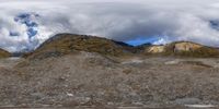 a big mountains area that has some rocks on it and people riding bikes near by