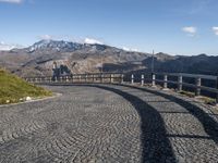 stone road in mountains with hills in the background on a sunny day in italy at the edge