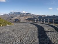 stone road in mountains with hills in the background on a sunny day in italy at the edge