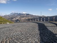 stone road in mountains with hills in the background on a sunny day in italy at the edge