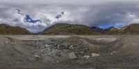 the camera is positioned in front of a big mountain range with low mountains in the background