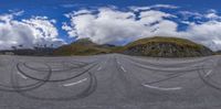 the view of the mountain range with the road painted black in the form of circles