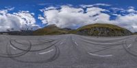 the view of the mountain range with the road painted black in the form of circles