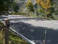 a man is riding his bike down the road towards a scenic view of mountains and trees