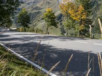 a man is riding his bike down the road towards a scenic view of mountains and trees