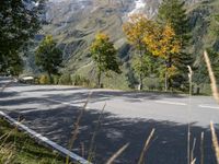 a man is riding his bike down the road towards a scenic view of mountains and trees