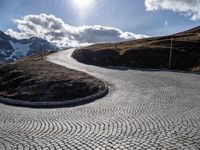 a cobblestone road with a view in the distance on the top of a mountain