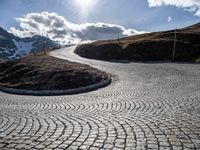 a cobblestone road with a view in the distance on the top of a mountain