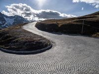 a cobblestone road with a view in the distance on the top of a mountain