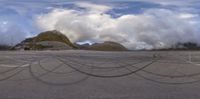 an aerial photo shows tire tracks on the ground near mountains and clouds in a blue sky