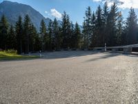 a mountain road with trees and a bench and trees to the side of the road