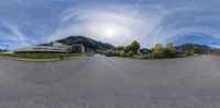 a wide fish eye lens shot of the mountain tops and cars on a road in an upscale area