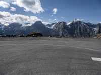 an airport runway with people standing around on it with the mountains in the background and in the distance