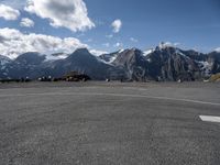 an airport runway with people standing around on it with the mountains in the background and in the distance