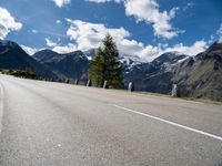 a mountain range is shown near an empty road in the background and with mountains in the distance