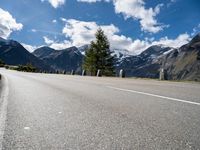 a mountain range is shown near an empty road in the background and with mountains in the distance