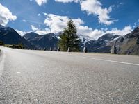 a mountain range is shown near an empty road in the background and with mountains in the distance