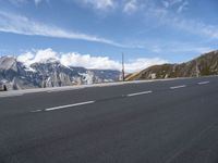 an empty highway is shown on the side of the road near mountains and telephone poles