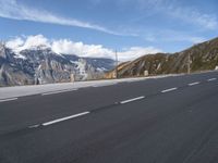 an empty highway is shown on the side of the road near mountains and telephone poles